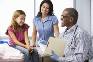 Doctor In Surgery Examining Young Girl